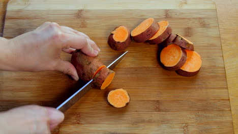 hand slices sweet potatoes