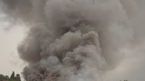 black smoke clouds and flames rise into the sky.