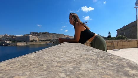 young woman looking over the ocean view and thinking about life. being serious, sad and lost in her own thoughts. wondering what to do on a sunny day, slow motion