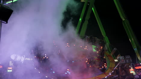 carrusel giratorio gigante con humo, gente divirtiéndose, tiro ancho estático