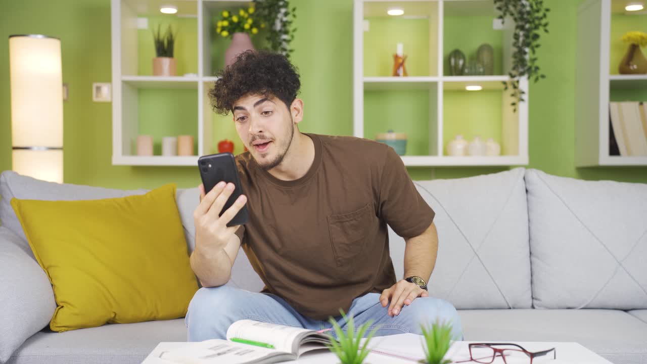 행복한 젊은이가 전화로 비디오 채팅을 하고 있습니다.