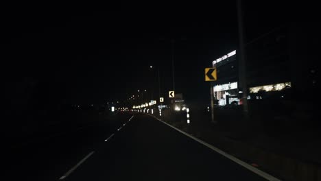 curved road at night isolated under black sky with light reflected from traffic lights in slow motion