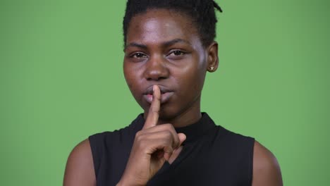 young beautiful african businesswoman with finger on lips