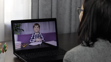 woman teacher making video call on laptop with little pupil. distance education