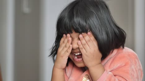 a happy little girl playing hide-and-seek