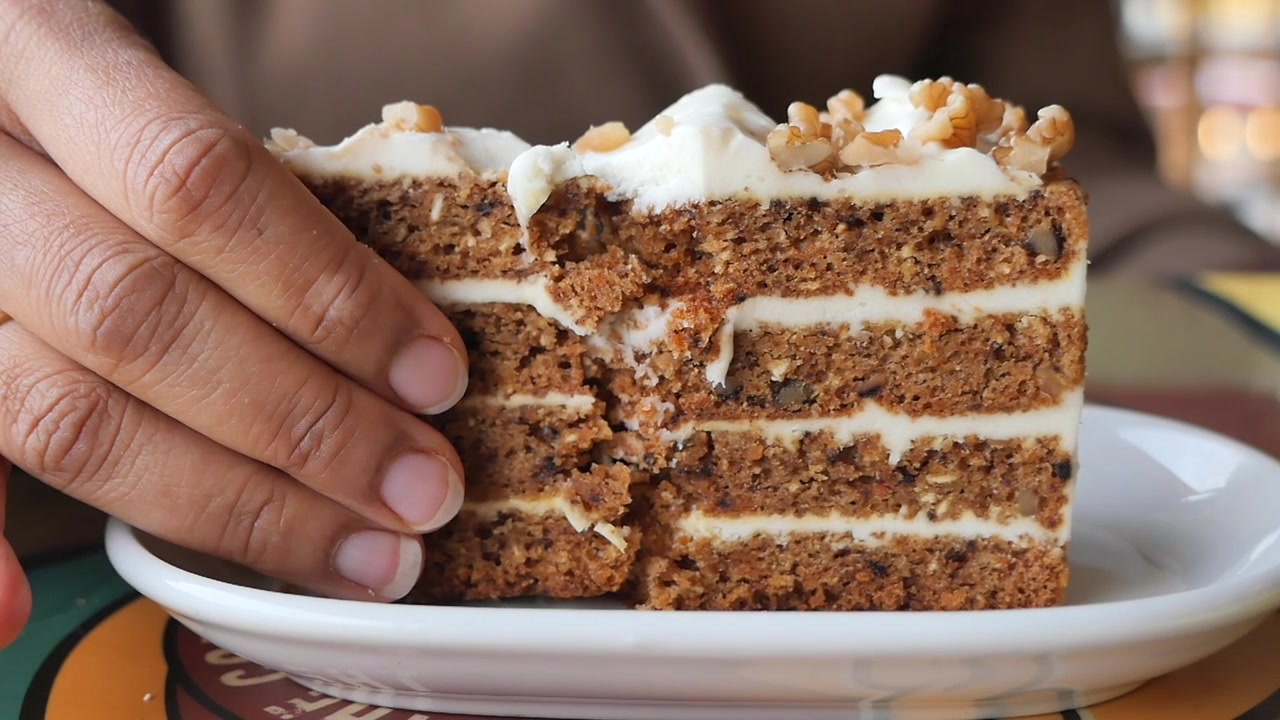 Person Taking a Bite of Layered Carrot Cake