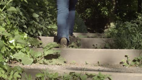 Legs-walking-up-outdoor-wooden-staircase-entrance