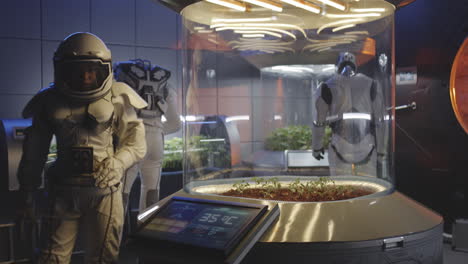 astronauts and robots working in a space greenhouse