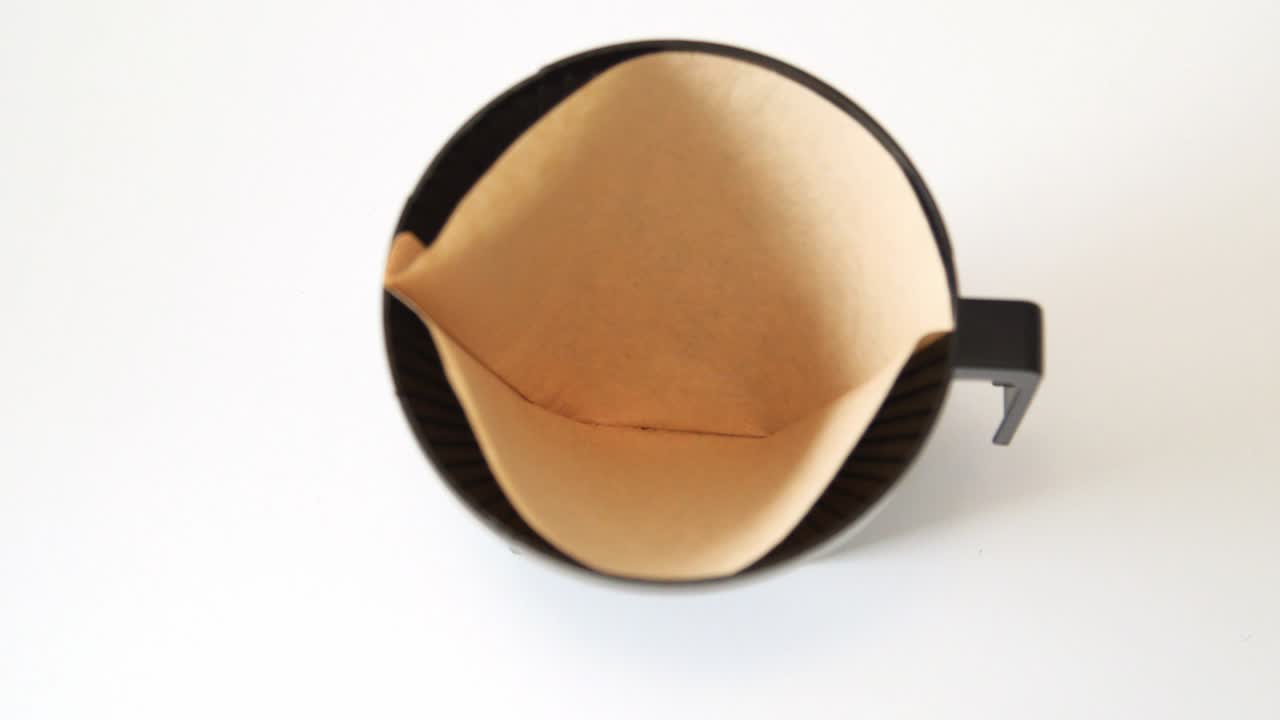 드립 커피 머신의 커피 퍼널에 필터를 채우고 신선한 커피를 채우는 탑샷