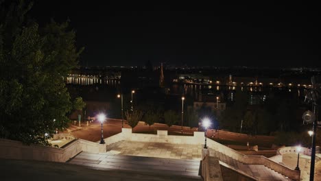 escalones iluminados y farolas con vistas al horizonte de budapest y al danubio por la noche