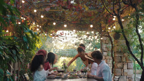 friends making toast celebrating dinner party drinking wine eating mediterranean food sitting at table enjoying beautiful summer day outdoors 4k footage