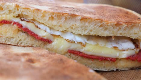 a delicious sandwich with cheese, tomato, and meat