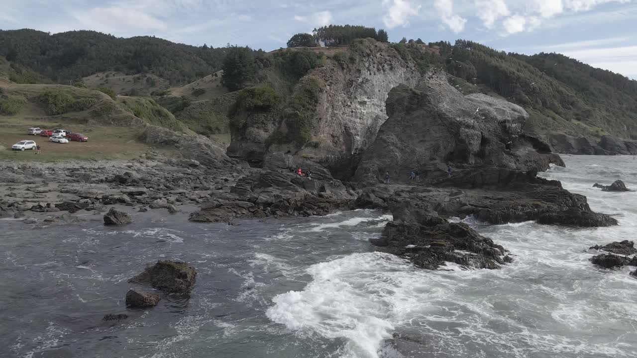 empujar toma aérea de formaciones rocosas en la costa de chile "pilolcura" con turistas visitando
