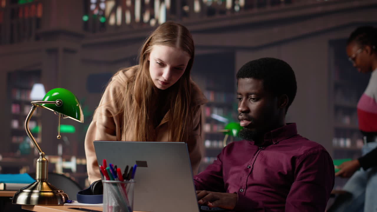 Vertical video diverse students working together on a college assignment at the library