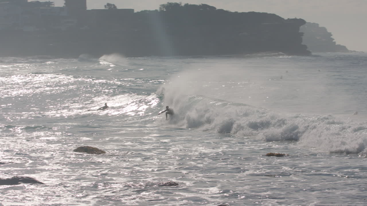 Find and zoom in on a surfer catching an awesome wave at manly beach in sydney australia