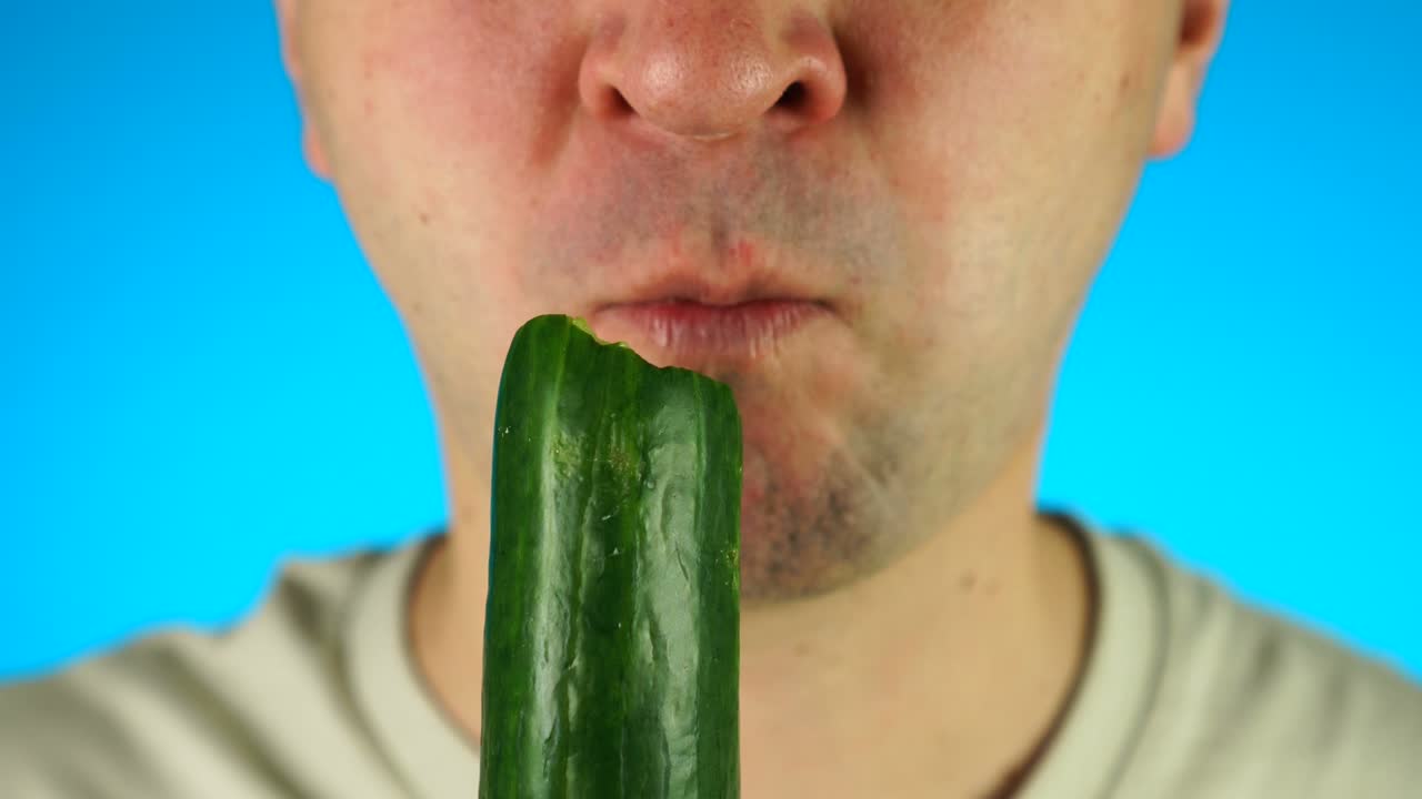 남자가 호박을 물고 먹습니다. 남성 얼굴 하반기의 클로즈업, 채소를 먹습니다.