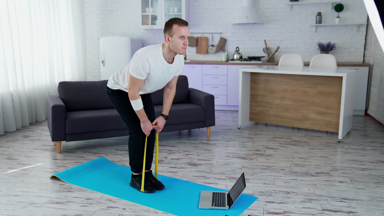 Lifestyle strong man training his body in home. Quarantine man doing exercise indoor.