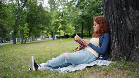 teenage girl reading in the park