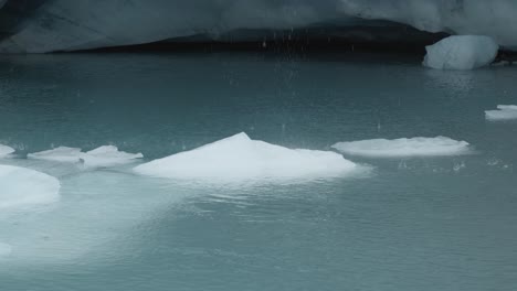 Agua-Que-Gotea-Sobre-El-Hielo-En-Un-Lago-Glaciar-En-Brewster-Track-En-El-Parque-Nacional-Mount-Aspiring,-Nueva-Zelanda