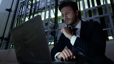 Arabic businessman hotel atrium night using laptop computer