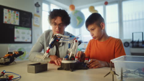 child and teacher working on a robot arm project