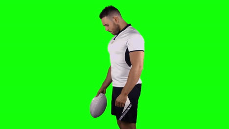 Serious-rugby-player-holding-ball-