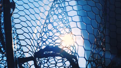 sun shining through black fishing net, low angle pan