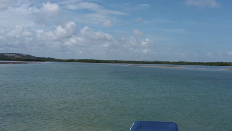 dolly en un drone aéreo filmado pasando por pequeñas embarcaciones de motor atracadas en un gran banco de arena de la laguna de guaraíras durante la marea baja en tibau do sul, brasil en río grande do norte en un cálido día soleado de verano
