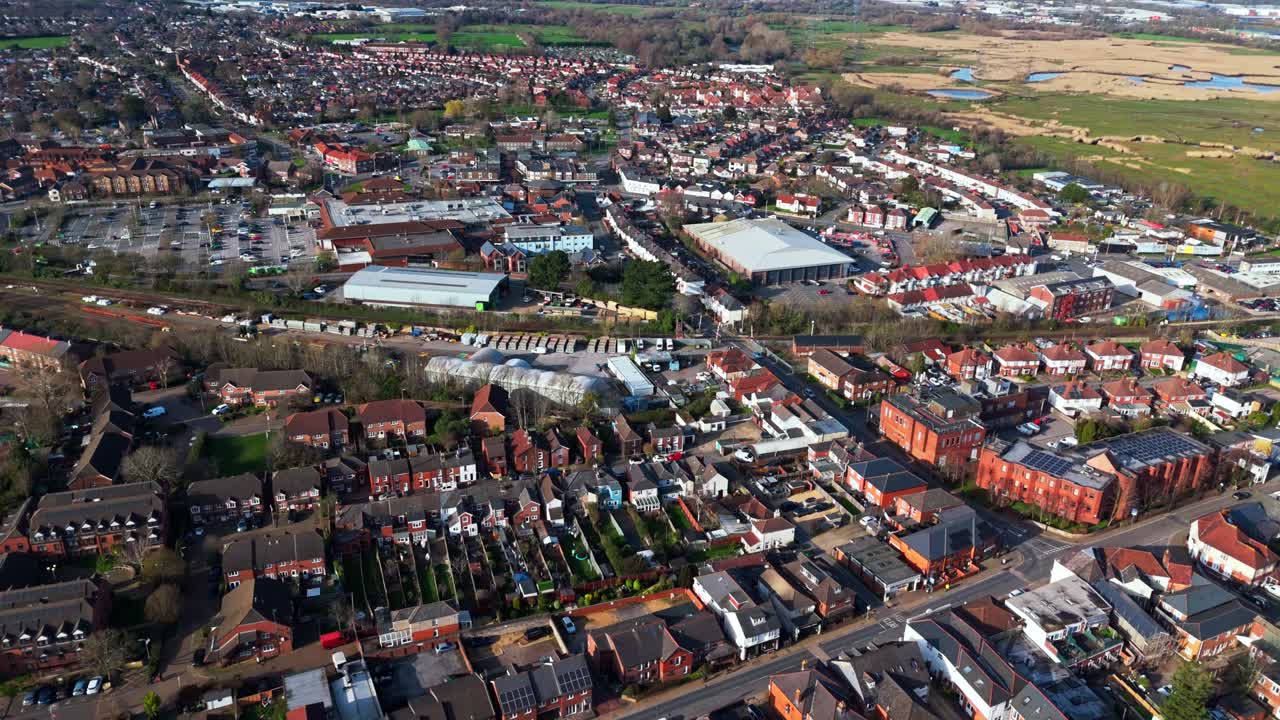 Luftpanoramaoptagelse over Totton-forstaden vest for floden i Southampton, England, med biler, der kører på de travle veje, og sollys, der reflekteres på det blå flodvand med både på den om vinteren.