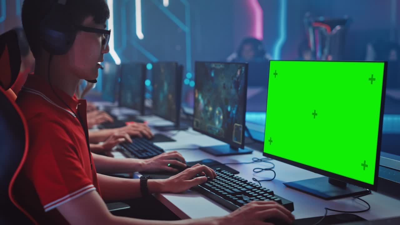 un jugador profesional juega en un videojuego con una maqueta de pantalla verde en un campeonato. equipo de jugadores profesionales en una elegante arena de juegos cibernéticos de neón. transmisión en línea del torneo. vista lateral