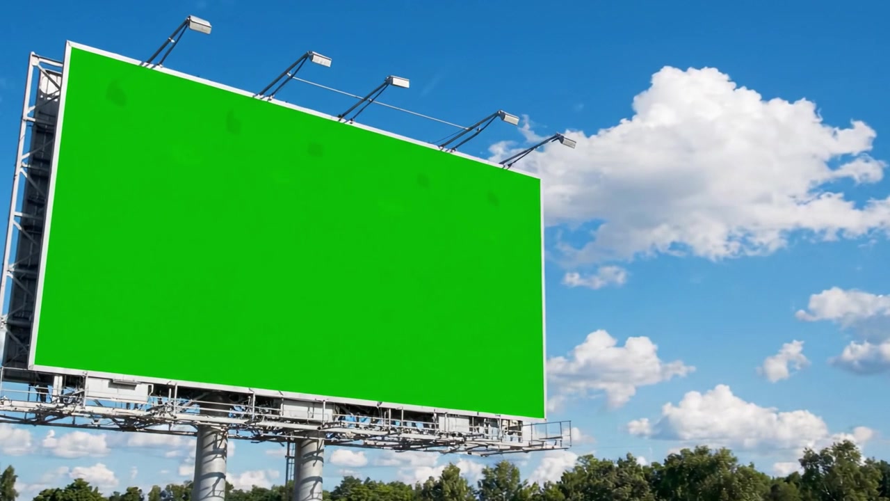 Un Vivace Cartellone Pubblicitario Vuoto Verde Sotto un Cielo Sereno con Nuvole Soffici, Ideale per Pubblicità e Promozioni, Pronto a Catturare l'Attenzione nel Paesaggio Urbano