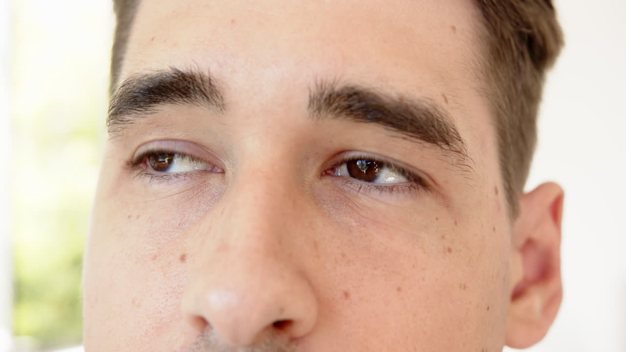 Close-up of man's eyes and eyebrows, looking upwards with curiosity, at home