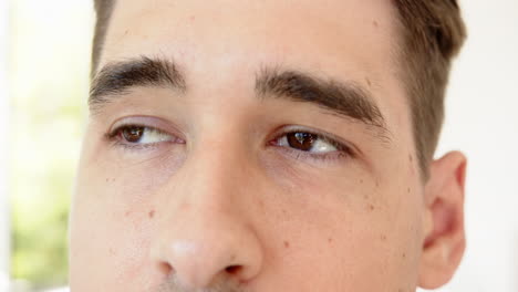 close-up of man's eyes and eyebrows, looking upwards with curiosity, at home