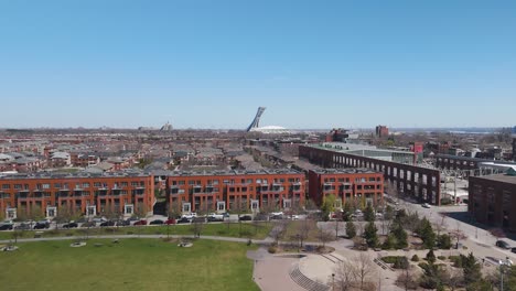 Un-Dron-Vuela-Sobre-El-Distrito-De-Hochelaga-Maisonneuve-Acercándose-Al-Estadio-Olímpico-De-Montreal