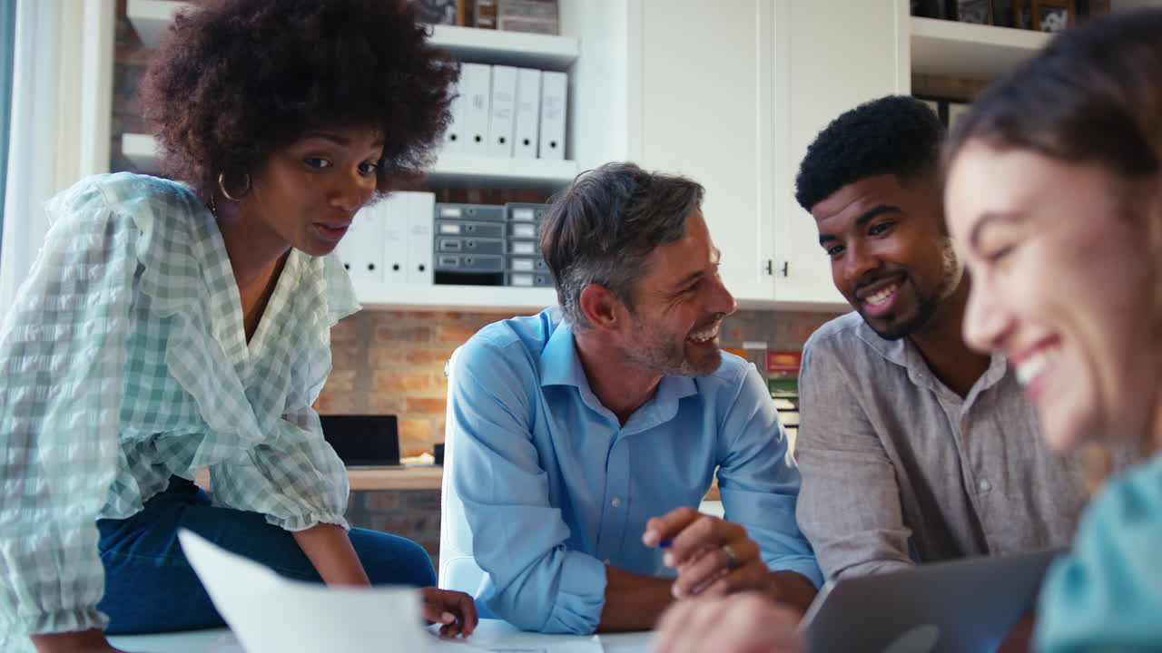 Male And Female Business Team With Laptop Meeting In Modern Office
