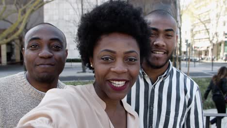 amigos afroamericanos sonrientes grabando un mensaje en video