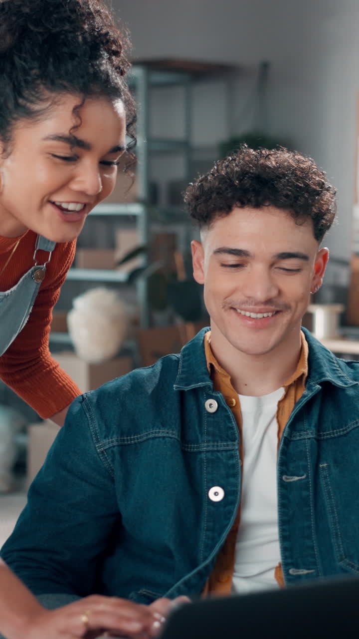 Jovem e mulher colaborando e sorrindo enquanto trabalham no laptop