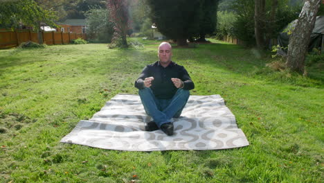 a man meditating in a yoga position in a garden