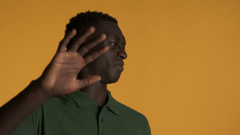 un hombre afroamericano disgustado sobre un fondo amarillo.