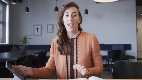 feliz mujer de negocios caucásica casual haciendo una videollamada en el escritorio, cámara lenta