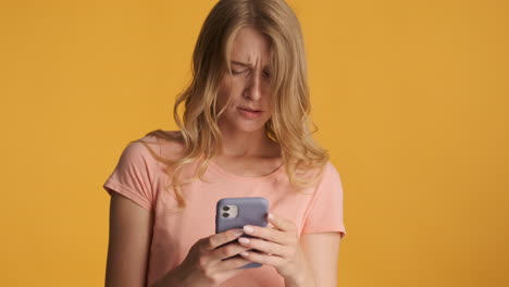 Caucasian woman using smartphone and getting upset on camera.