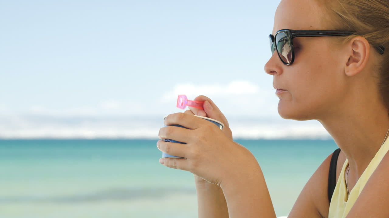 Donna che mangia un gelato in spiaggia