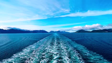 Estela-Oceánica-En-Agua-Azul-En-Un-Barco-Que-Navega-Lejos-De-La-Isla-Y-Las-Montañas-En-Segundo-Plano