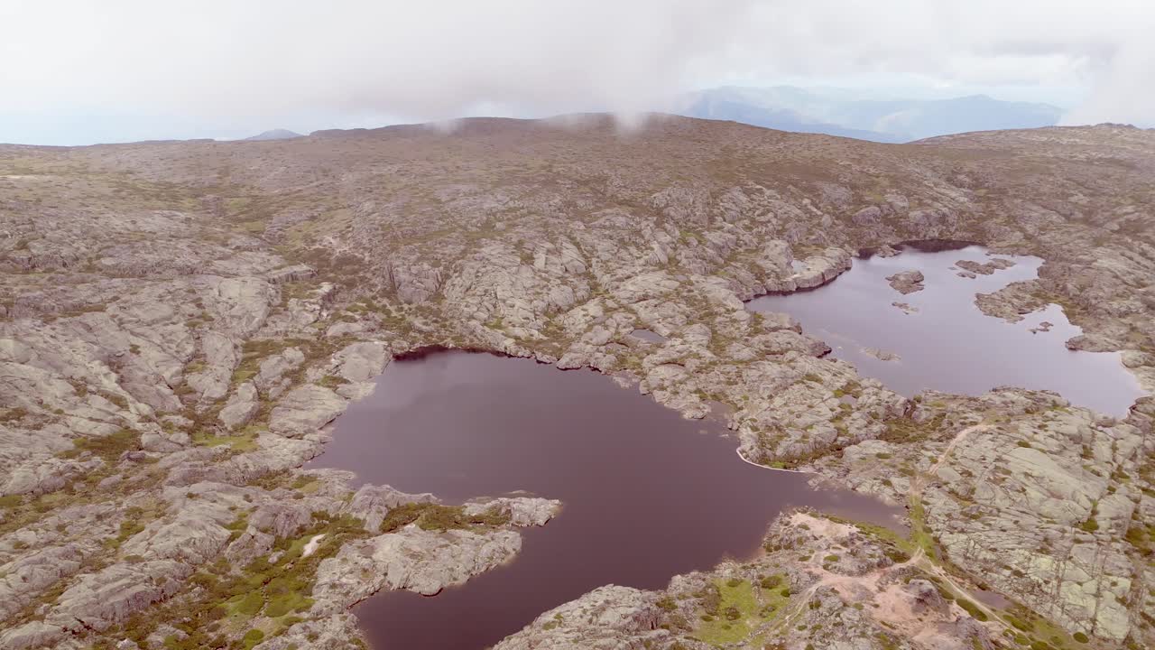 аэрофотосъемка панорамного вида на самую высокую точку serra de estrella, включая озеро и окружающий ландшафт