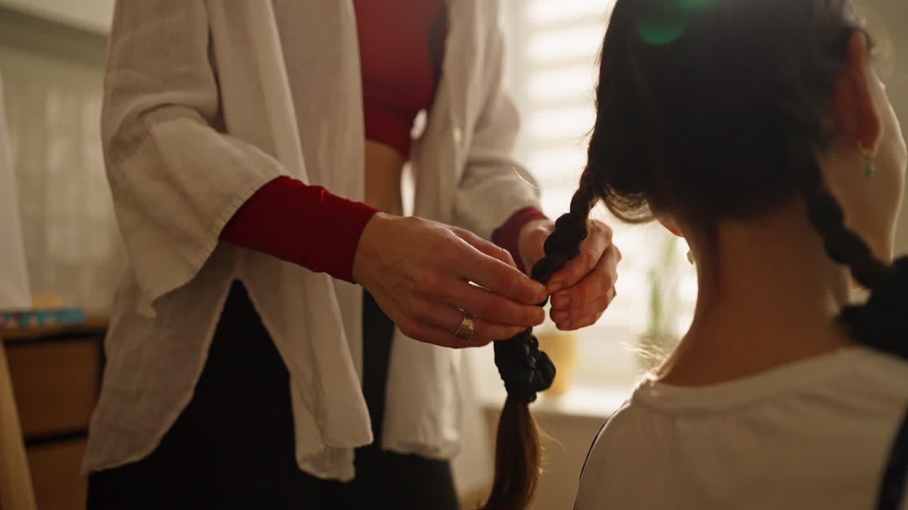 madre trenzando el cabello de la hija