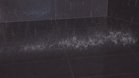 Water-drops-fall-at-the-black-tiled-floor