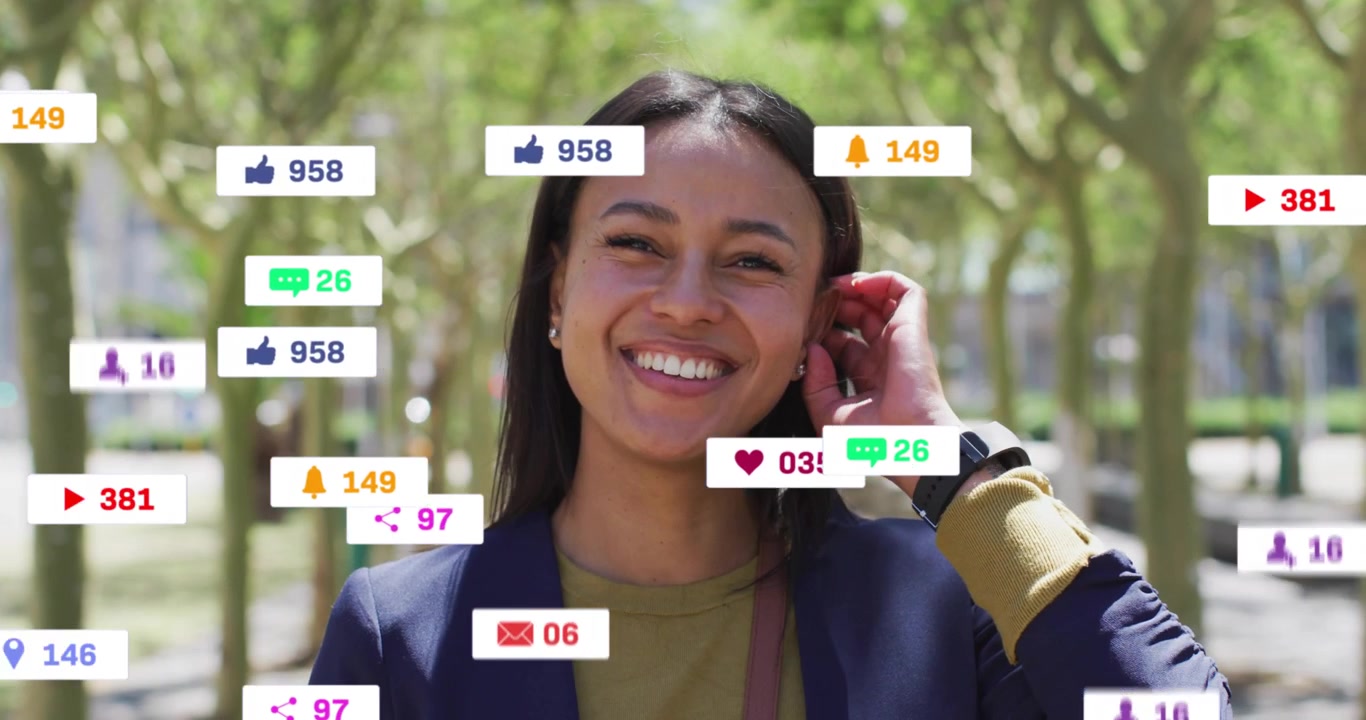 Content creator receiving alert reacting to social media icons swirling around face as she smiles