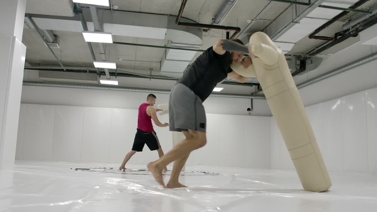 두 명의 남성 레슬링 선수가 느린 동작으로 매트에 인형 던지기를 수행합니다. 전문 레슬링 전투기