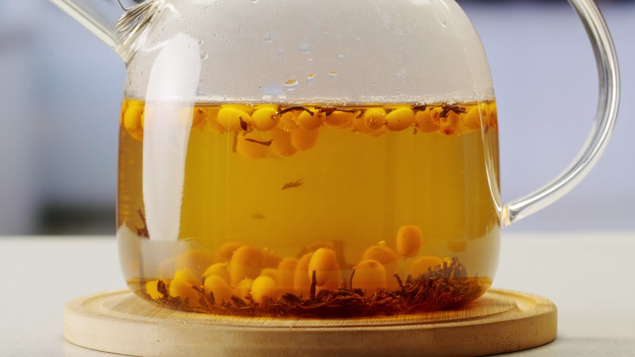 해바라기 건강한 베리 차 음료, 유리 항아리 및 잎을 가진 가지에 얼어붙은 익은 베리 어두운 나무 농촌 배경에  뷰, 피부, 심장, 혈관 및 면역 체계에 훌륭합니다.