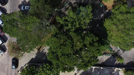 aerial camera pushing in and over the park of santiago and the colonial church of santiago apostol, merida, yucatan, mexico